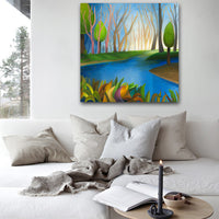 Painting of a forest scene with a lake on a wall above a sofa.